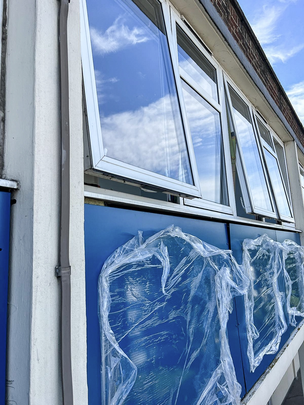 Close view of newly installed blue facade panels around existing windows