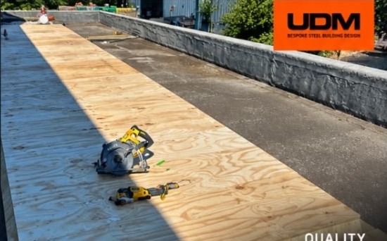 New plywood roof decking being installed during the flat roof refurbishment in Harlow by UDM