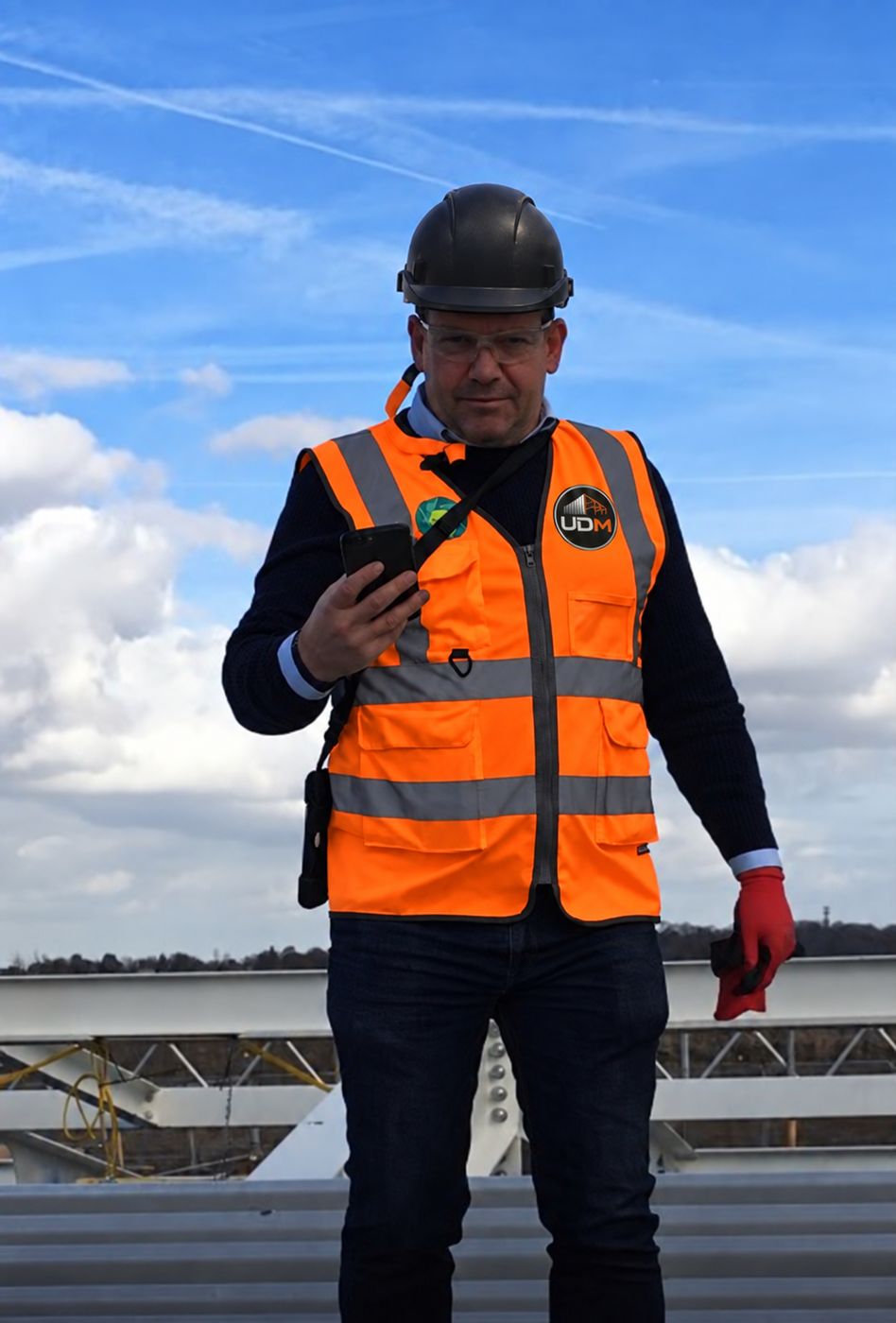 UDM team member in branded safety clothing on the roof at Springwood Court